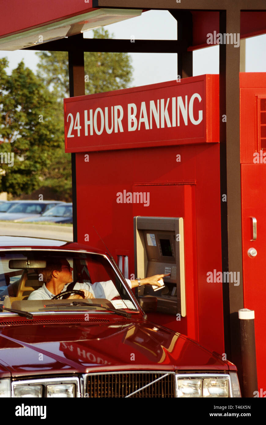 1995, Man conducting Transaction at a drive thru 24 hour ATM, USA Stock Photo