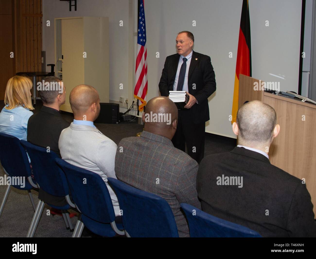 GARMISCH-PARTENKIRCHEN, Germany (March 12, 2019) – Retired U.S. Marine Corps Col. James Howcroft, Marshall Center’s program director for the Program on Terrorism and Security Studies, hands out the “Combatting Transnational Terrorism” textbook to the seven future participants during the graduation ceremony of English Language Enhancement Course March 12 here. This book will used daily during PTSS 19-07 and was edited by the Marshall Center’s PTSS Team. Professor James Wither and Dr. Sam Mullins edited the book, which has contributions from PTSS alumni. This ELEC is a specially tailored program Stock Photo