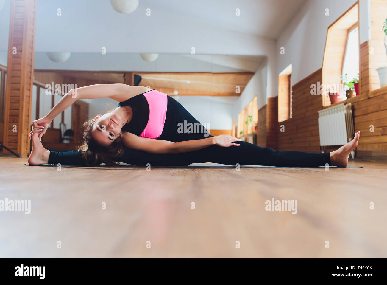 Woman stretching yoga. Sirsasana, Supta upavistha konasana pose. Stock Photo