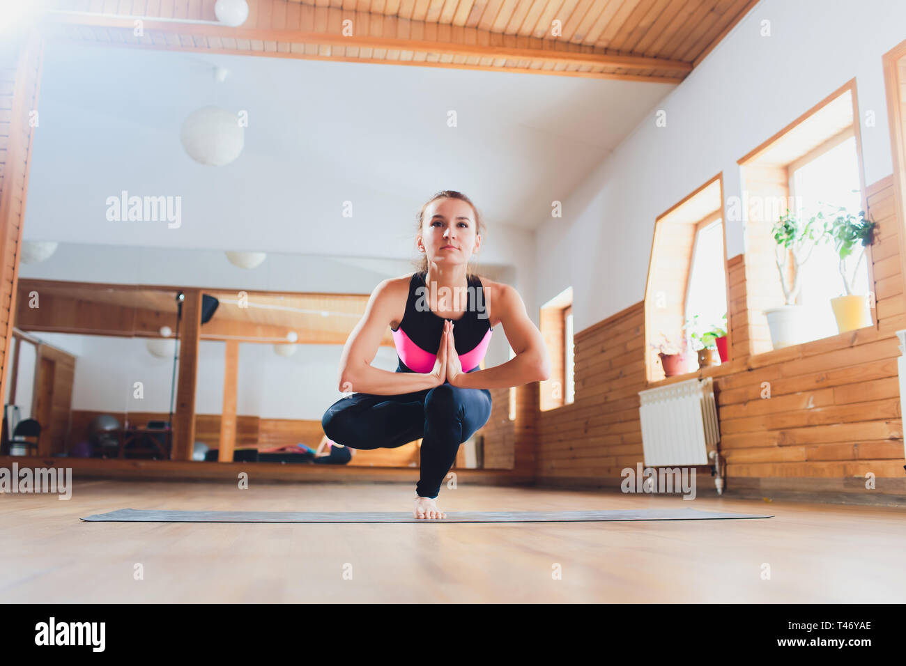 young woman doing one legged squat yoga pose outdoors Stock Photo - Alamy