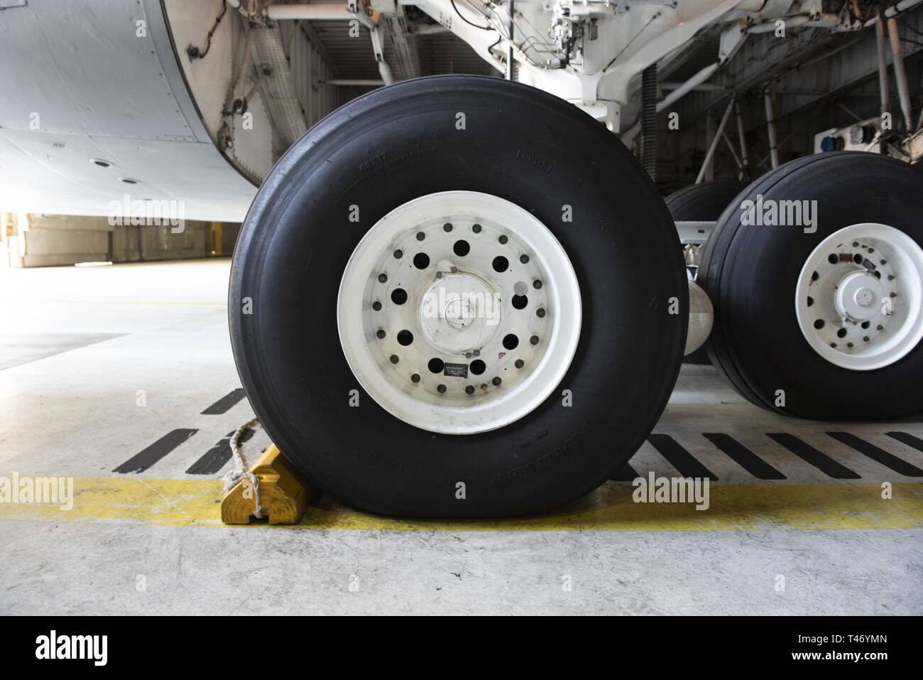 The rear wheel assembly of a C5M Super Galaxy aircraft is serviced