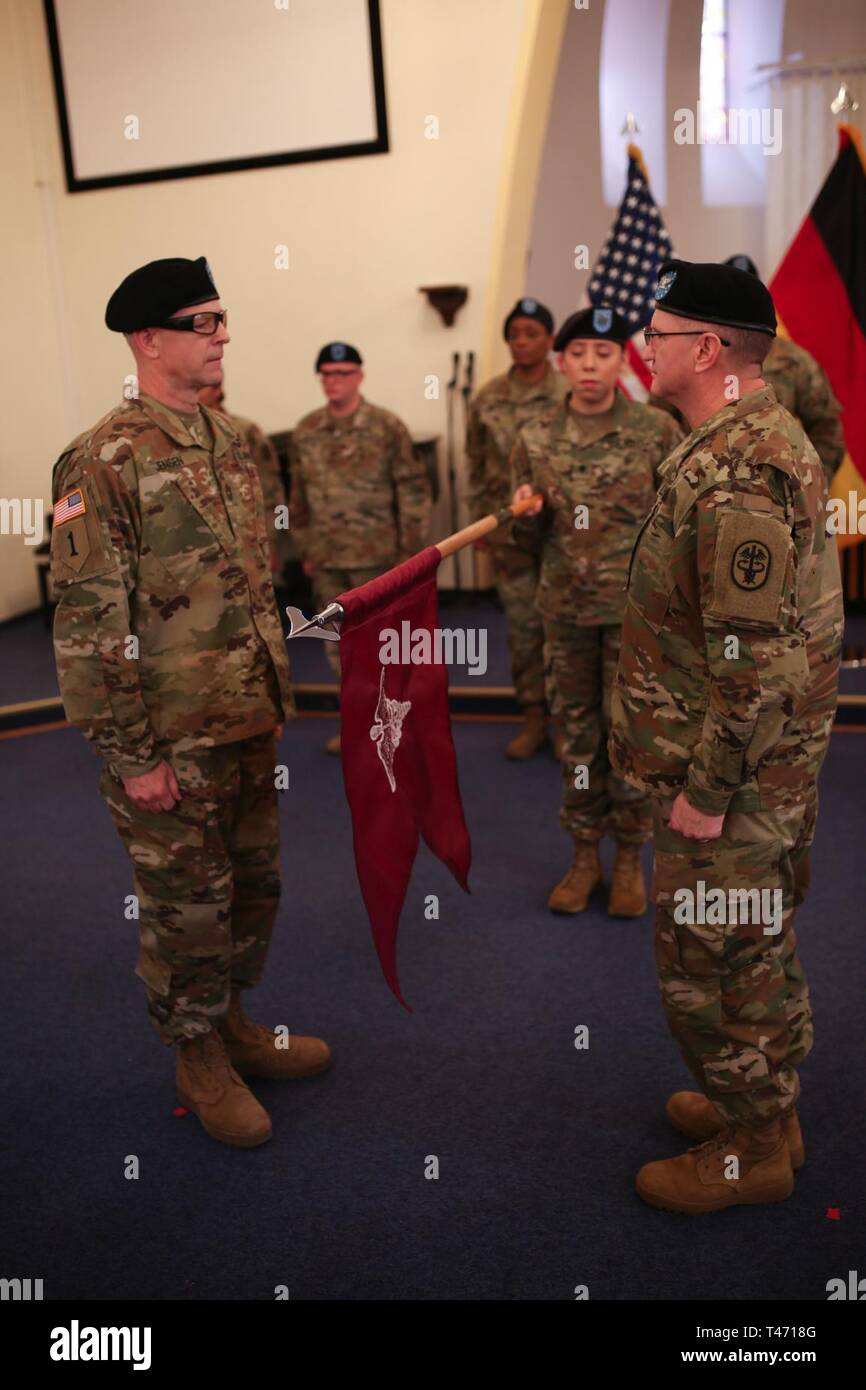 Col.Paul G. Graham, Commander of the 7234th Medical Support Unit, hoists the guidon with Master Sgt. Steven Jensen during the transfer authority of the Deployed Warrior Medical Management Center from the 7221st MSU to the 7234th MSU at Landstuhl Regional Medical Center in Landstuhl, Germany, on March 14, 2019. Stock Photo