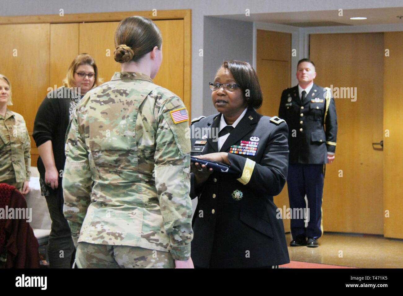 Brig. Gen. Twanda Young (right), deputy commanding general for the U.S. Army Human Resources Command, gives a flag to Sgt. Christine Meyers with the Fort McCoy Army Health Clinic during the Women's History Month observance March 14, 2019, at McCoy's Community Center. Young was the guest speaker. Stock Photo