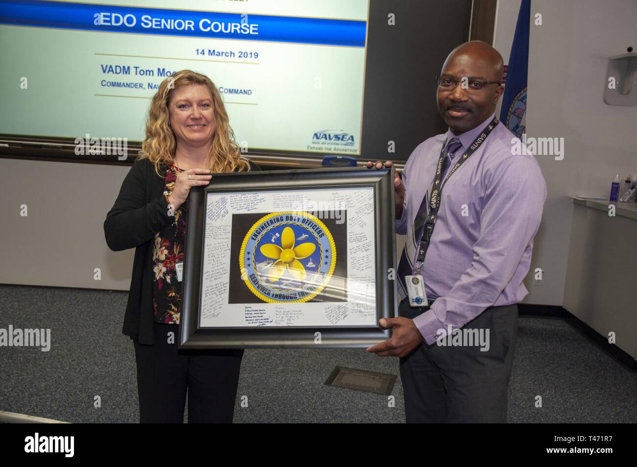 Port Hueneme Calif Timothy Haney Engineering Duty Officer Edo School Executive Director Presents A Plaque Signed By The Entire Edo Staff To Kristie Simpson Financial Management Analyst Naval Surface Warfare Center