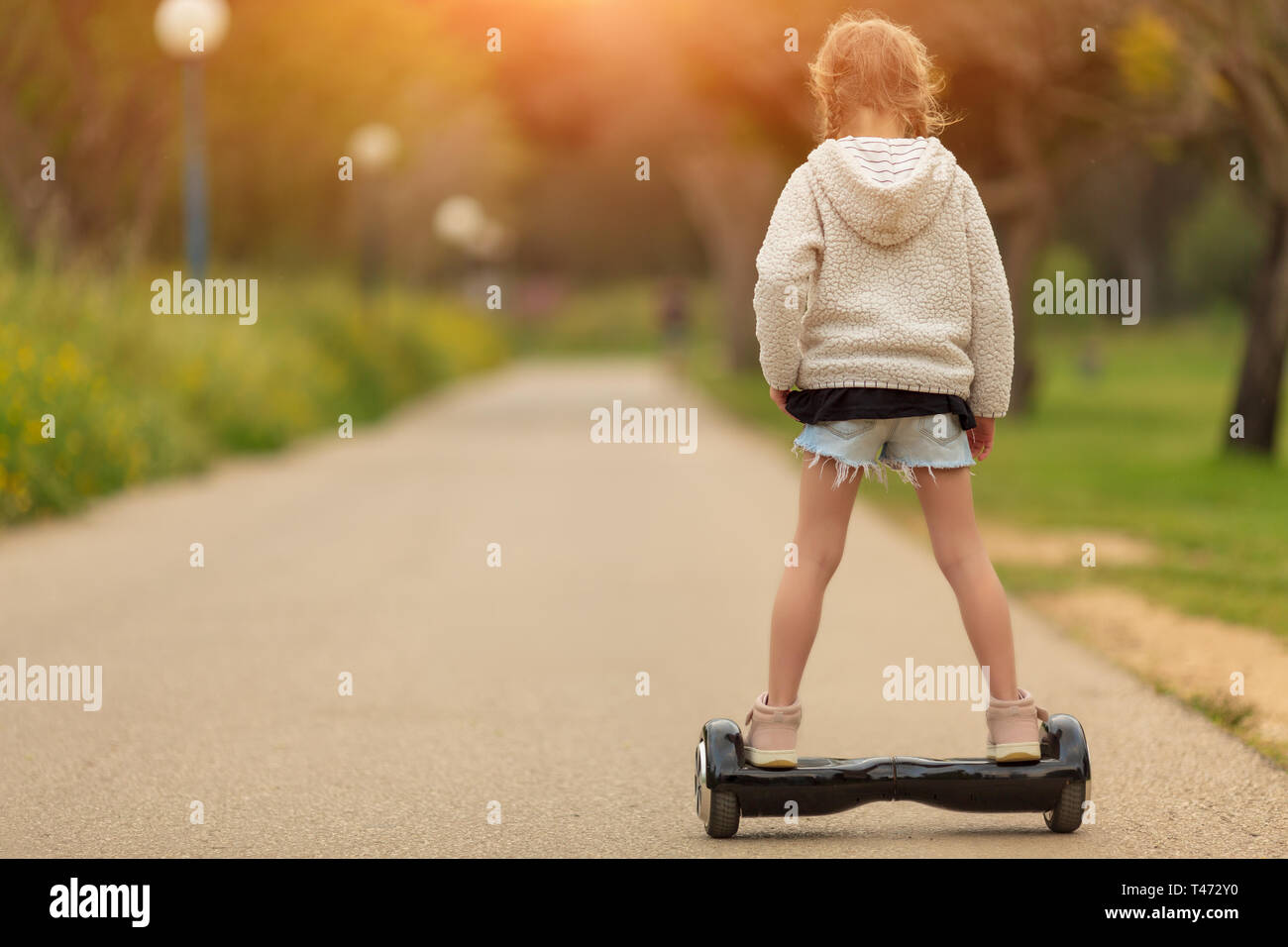 Girl riding on the hoverboard in the park Stock Photo