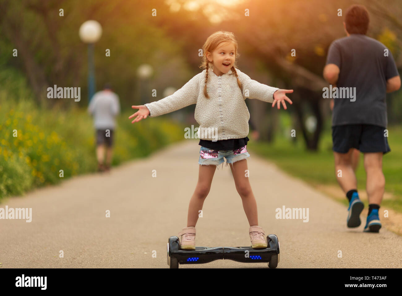 Girl learning to ride hoverboard. Modern gadgets for school kid Stock Photo