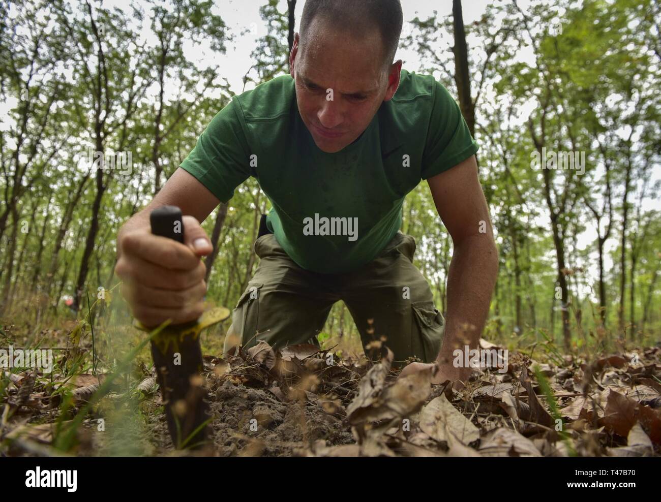 U.S. Army Capt. Jeramy Mahoney, medic with the Defense POW/MIA Accounting Agency (DPAA), digs for a piece of metal that was detected during a sweep of a rubber tree plantation in Binh Duong, Socialist Republic of Vietnam, March 11, 2019. During the 35-day mission, the team investigated several sites correlated with missing service members in hopes of recommending future recovery operations. DPAA’s mission is to provide the fullest possible accounting of our missing personnel to their families and the nation. Stock Photo