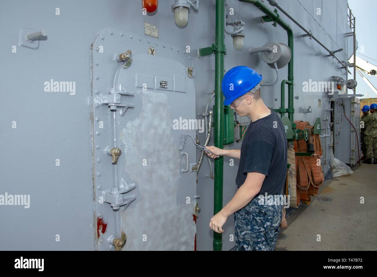 Fla. (Mar. 11, 2019) Fire Controlman 3rd Class Avery Doyle, from Allen Park, Mich., paints a quick acting water tight door aboard the Wasp-class amphibious assault ship USS Iwo Jima (LHD 7), Mar 11, 2019. Iwo Jima is currently at her homeport conducting Chief of Naval Operations Maintenance Availability. Stock Photo
