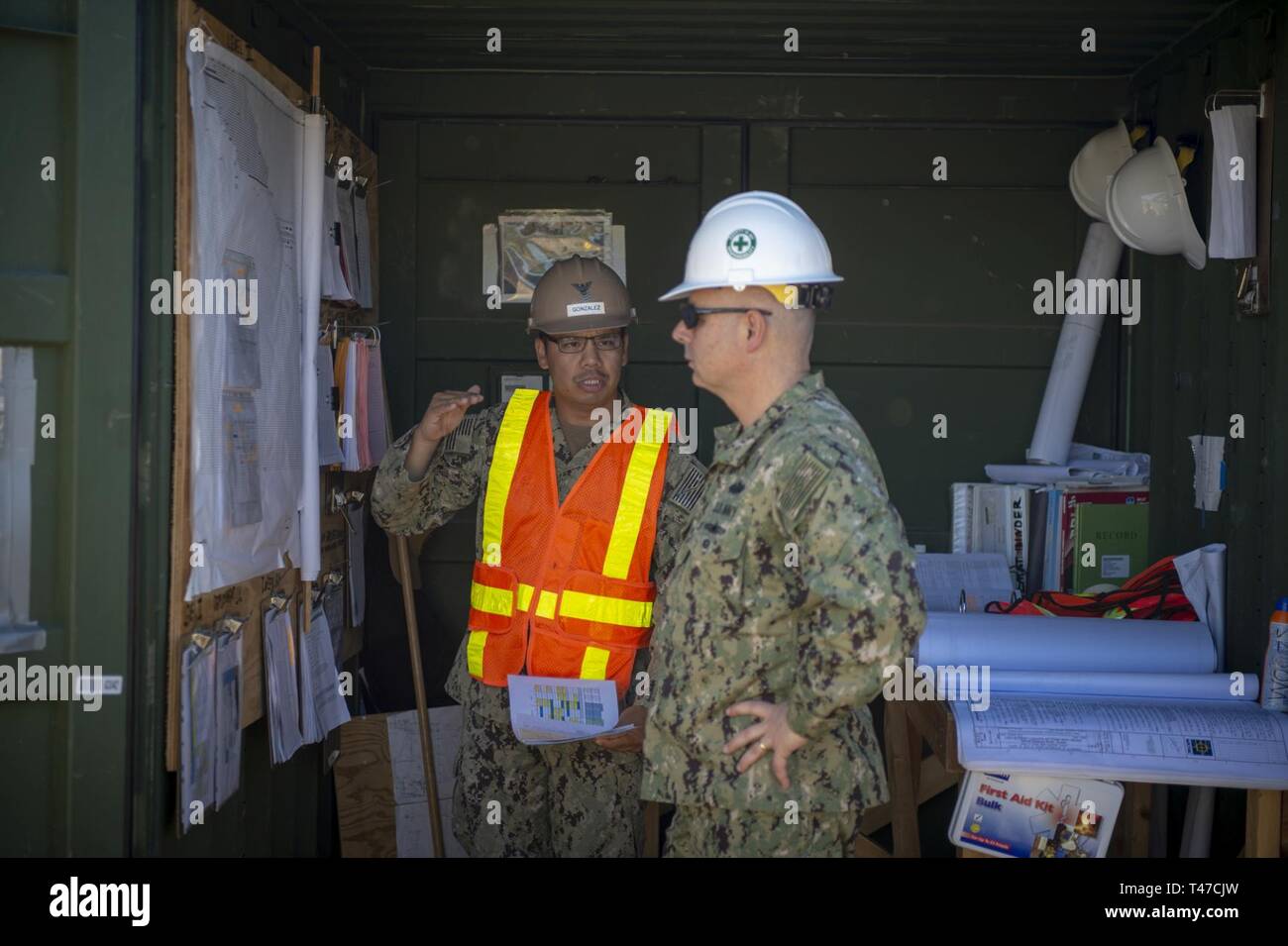 ROTA, Spain (March 15, 2019) Utilitiesman 1st Class Josue Gonzalez, assigned to Naval Mobile Construction Battalion (NMCB) 133, discusses the progress of the Tow Way Street lighting project site with Rear Adm. John Korka, commander of Naval Facilities Engineering Command, during his visit to Camp Mitchell onboard Naval Station Rota, Spain. NMCB-133 is forward deployed to execute construction, humanitarian and foreign assistance, and theater security cooperation in the U.S. 6th Fleet area of operations. Stock Photo