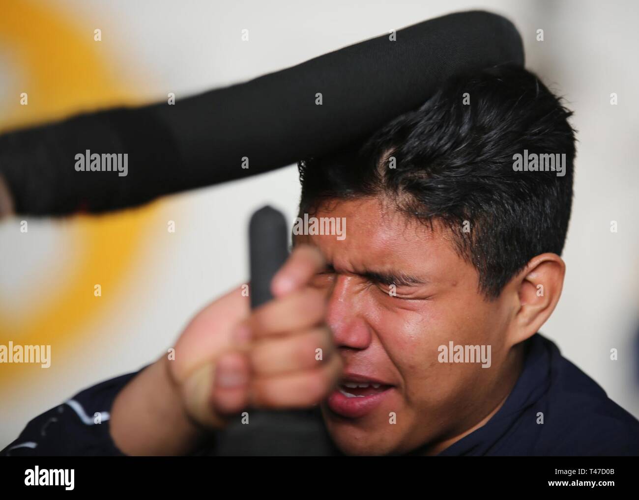 OCEAN (Mar. 15, 2019) Logistics Specialist Seaman Apprentice Luis Castillorojas tries to defend himself against his mock attacker during an oleoresin capsicum (OC)  course aboard the multipurpose amphibious assault ship USS Bataan (LHD 5) The ship is underway conducting sea trials. Stock Photo