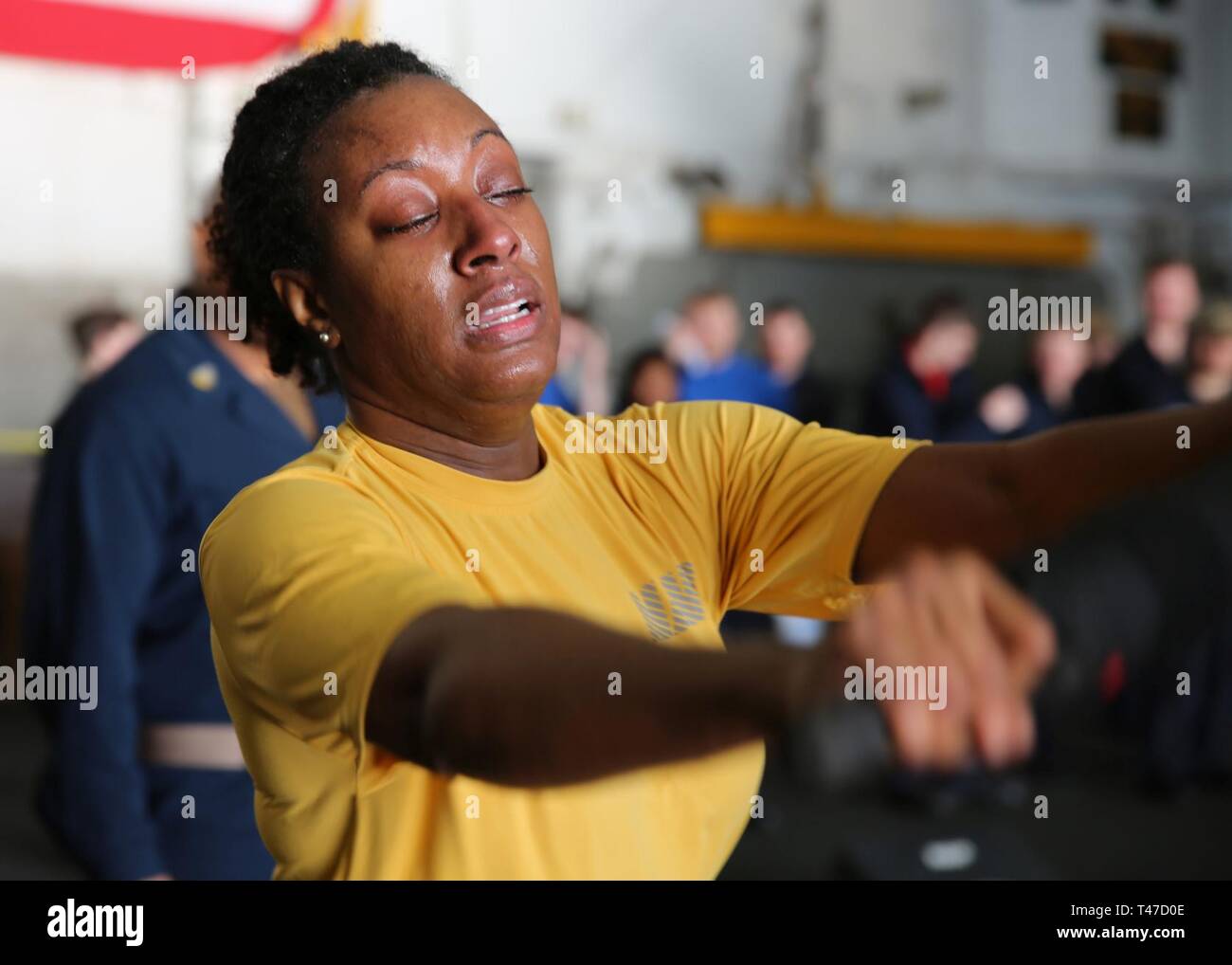 OCEAN (Mar. 15, 2019) Information Systems Technician 1st Class Chara Neal pushes back her mock attacker during an oleoresin capsicum (OC) course aboard the multipurpose amphibious assault ship USS Bataan (LHD 5) The ship is underway conducting sea trials. Stock Photo