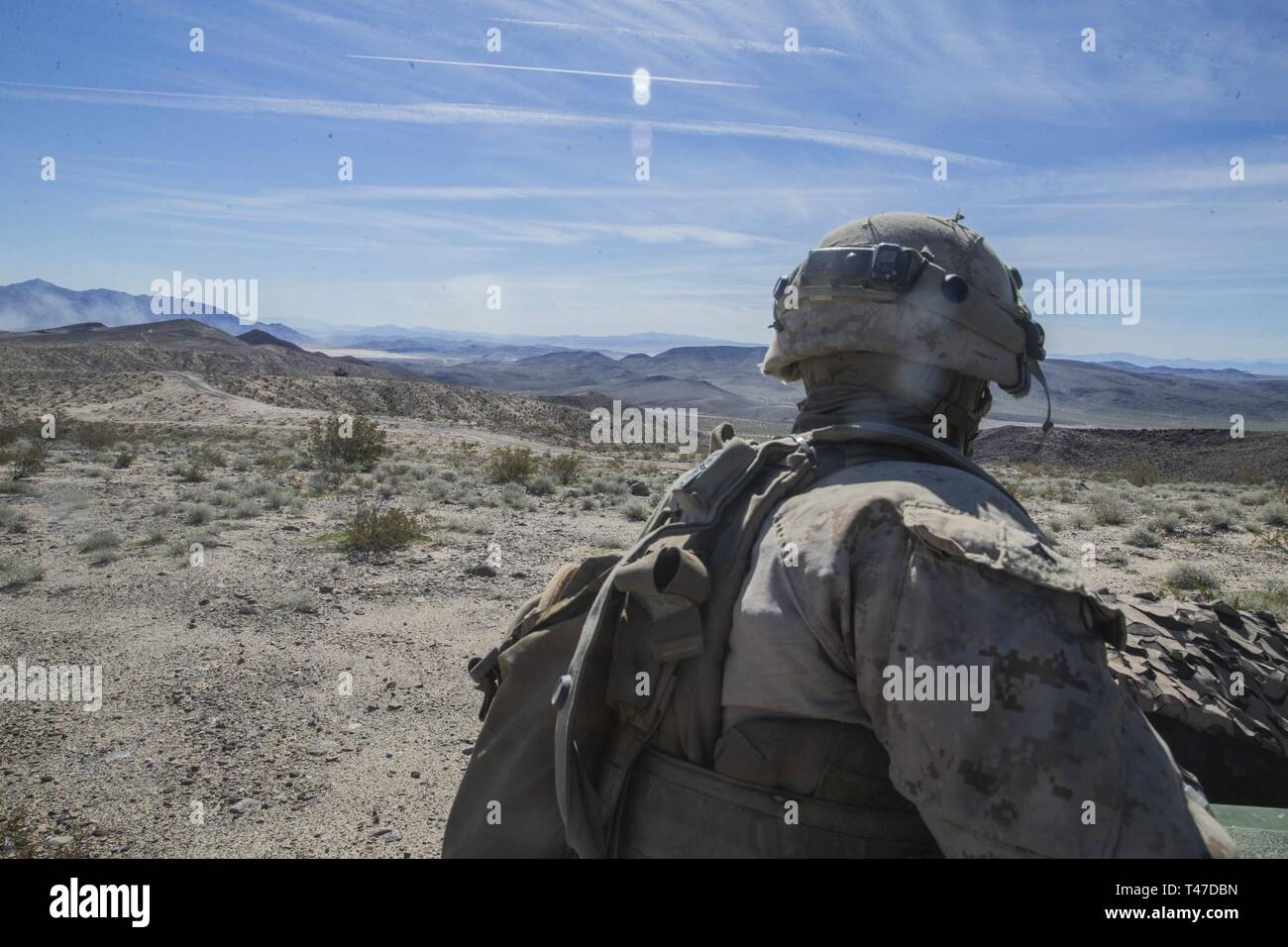 U.S. Marine Lance Cpl. Sam A. Pooley, a rifleman with 2nd Light Armored Reconnaissance Battalion, 2nd Marine Division scans the valley below during a deployment for training at Fort Irwin, California, March 15, 2019. The Marines of 2d Light Armored Reconnaissance Battalion participated in National Training Center 19-05 as the opposing force against the 2nd Armored Brigade Combat Team, 1st Infantry Division. The exercise provided Marines and Sailors an opportunity to sustain training in primary conventional combat operations against a peer competitor. Stock Photo