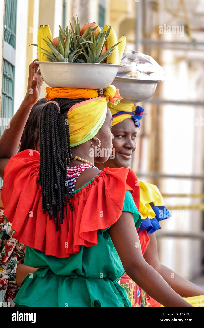 Cartagena Colombia,Black Afro Caribbean Palenqueras,woman female women,fruit vendor,traditional costume,cultural heritage symbol,carrying bowl on head Stock Photo