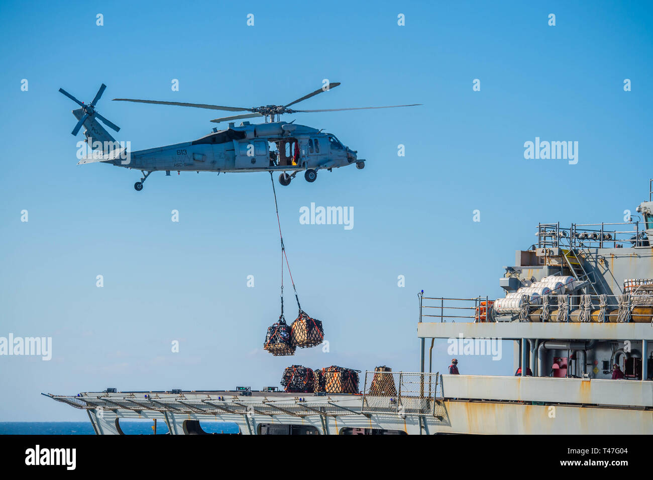 190412-N-DS741-0314 ATLANTIC OCEAN (April 12, 2019) An MH-60S Sea Hawk helicopter from the “Nightdippers” of Helicopter Sea Combat Squadron (HSC) 5, assigned to the Nimitz-class aircraft carrier USS Abraham Lincoln (CVN 72), conducts a vertical replenishment with the fast combat support ship USNS Arctic (T-AOE-8). Abraham Lincoln is underway as part of the Abraham Lincoln Carrier Strike Group (ABECSG) deployment in support of maritime security cooperation efforts in the U.S. 5th, 6th and 7th Fleet areas of responsibility. With Abraham Lincoln as the flagship, deployed strike group assets inclu Stock Photo