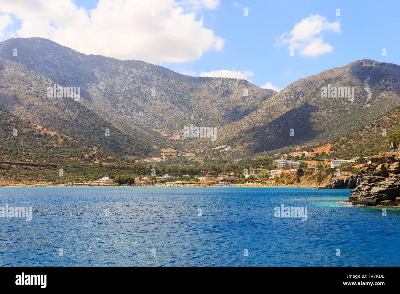 Sea Bay of resort village Bali. Views of mountain, shore, washed by waves and sun loungers. Bali, Rethymno, Crete, Greece Stock Photo