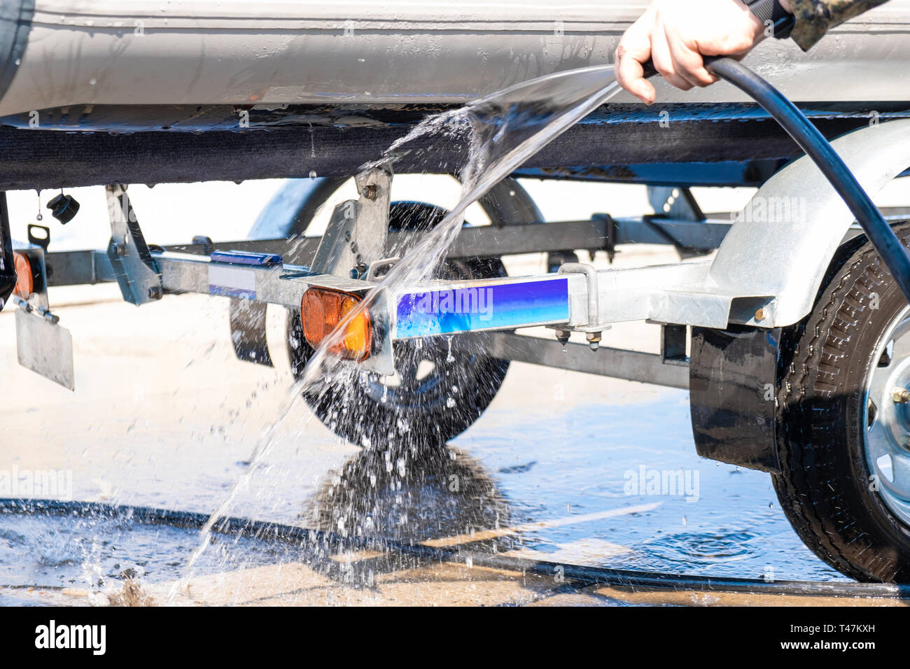 A man washes a rubber hose boat after going to sea. Drops of water