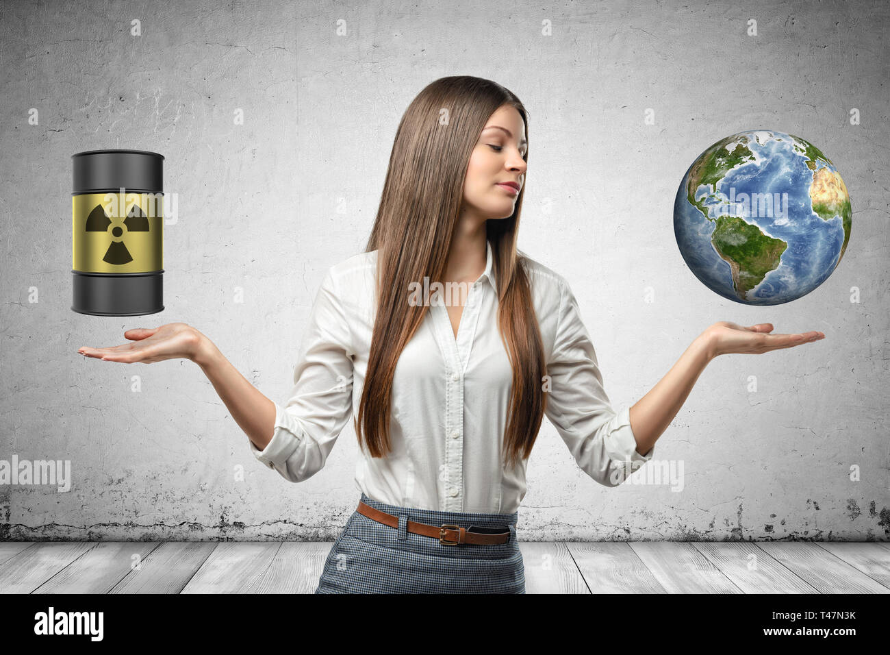 Businesswoman with hands to the side facing up, with barrel with ionizing radiation sign on it and small Earth, suspended in air above her palms. Stock Photo