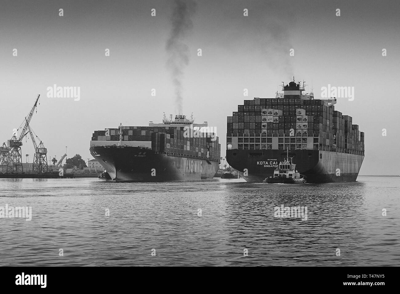 Black And White Photo Of The Departing Container Ship KOTA CAHAYA, Passing The Arriving YM UNANIMITY In The Narrow Los Angeles Main Channel. USA. Stock Photo