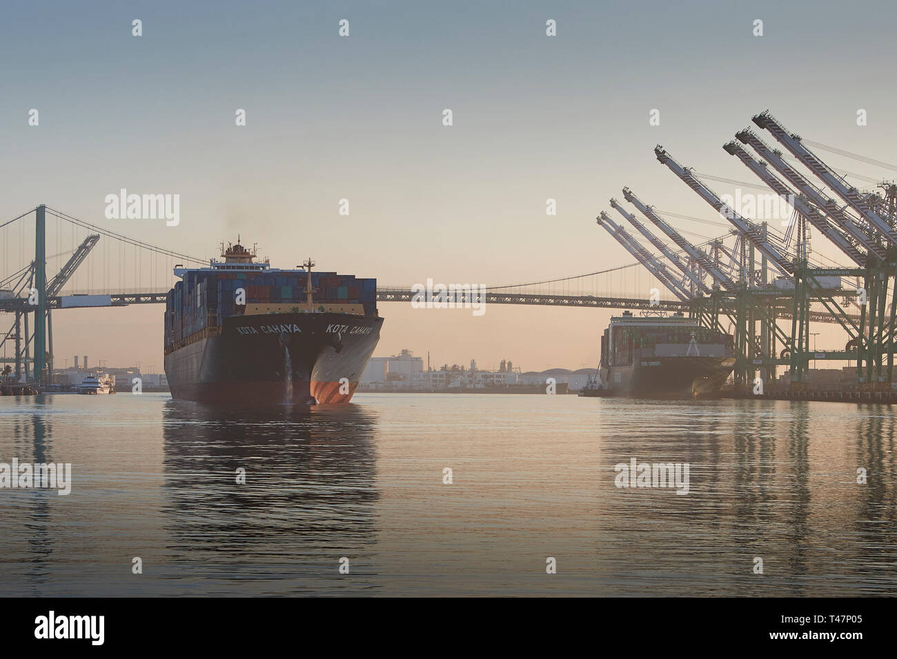 Container Ship, KOTA CAHAYA, Underway Through The Los Angeles Main Channel As She Departs The Port Of Los Angeles At Sunrise. California, USA. Stock Photo