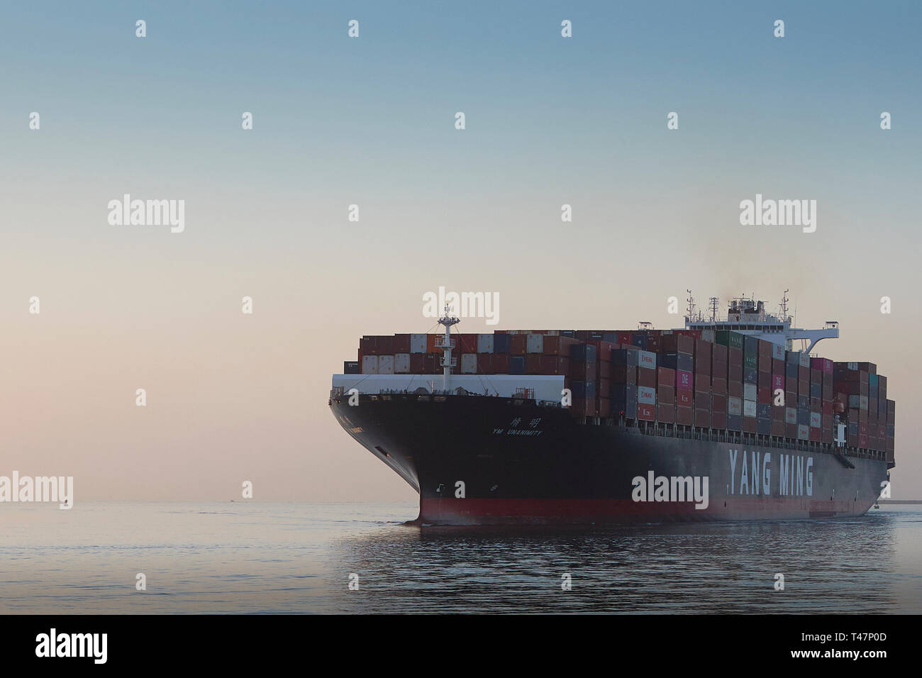 Head On Photo Of The Giant YANG MING Container Ship, YM UNANIMITY, At Sea, Steaming Towards The Port Of Los Angeles At Sunrise, California, USA. Stock Photo