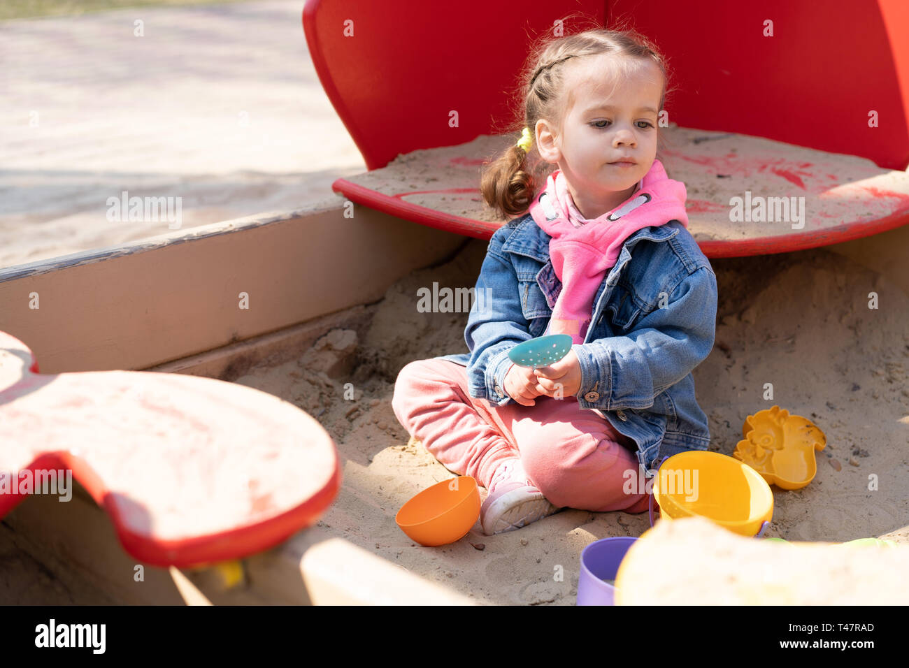 Cute little caucasian girl on the playground, happy child with pleasure spending time outdoors, happy carefree childhood Summer season childrens leisu Stock Photo