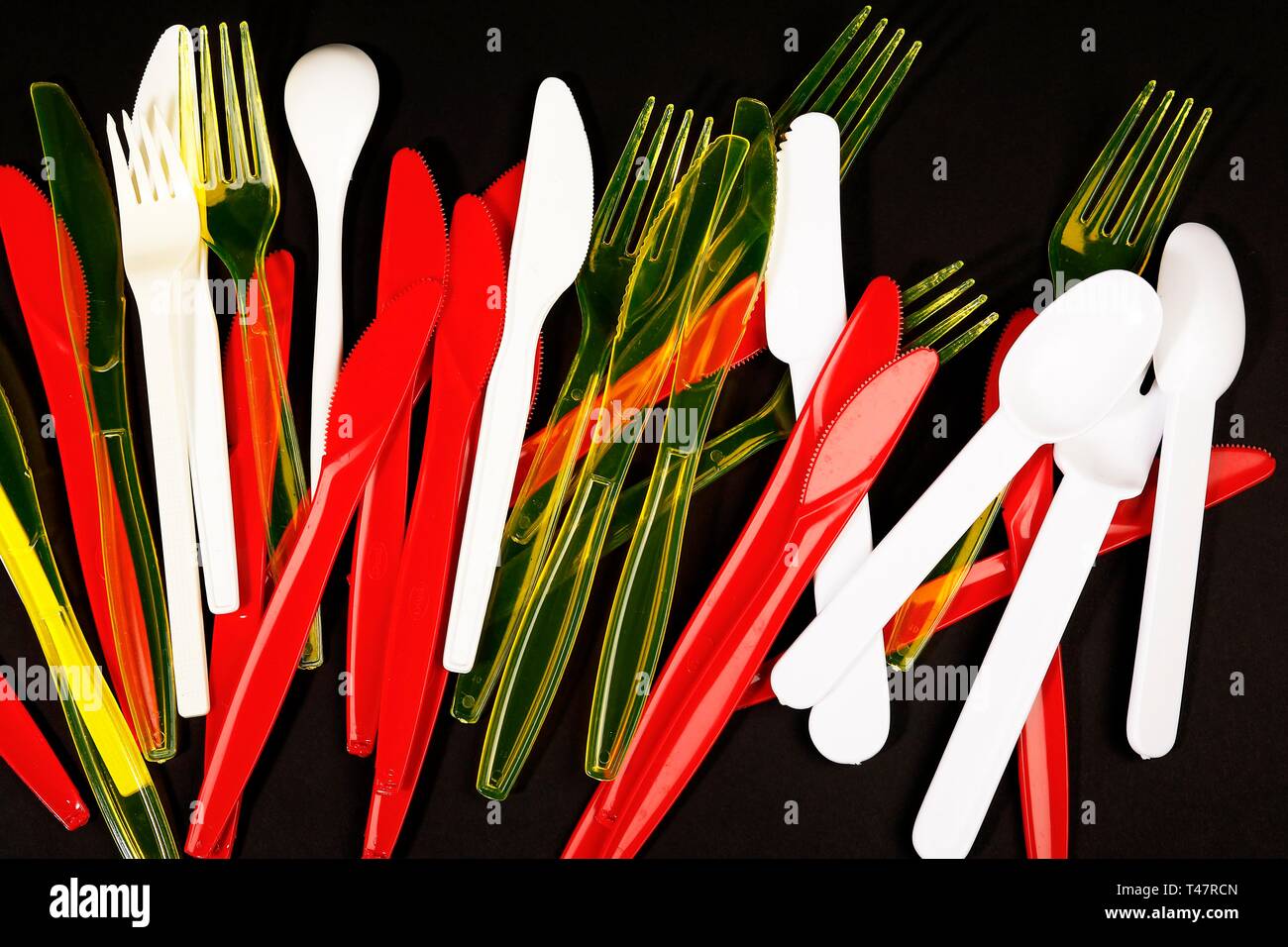 Red, yellow and white plastic cutlery, plastic knives, plastic forks
