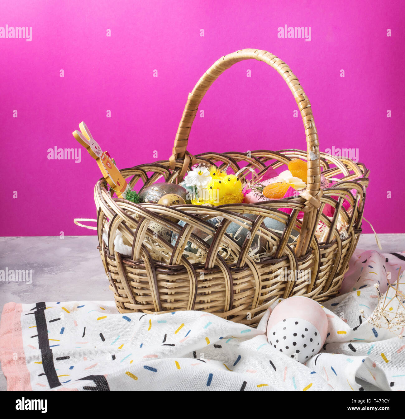 Basket with easter cakes and painted eggs on concrete background. Easter concept Stock Photo