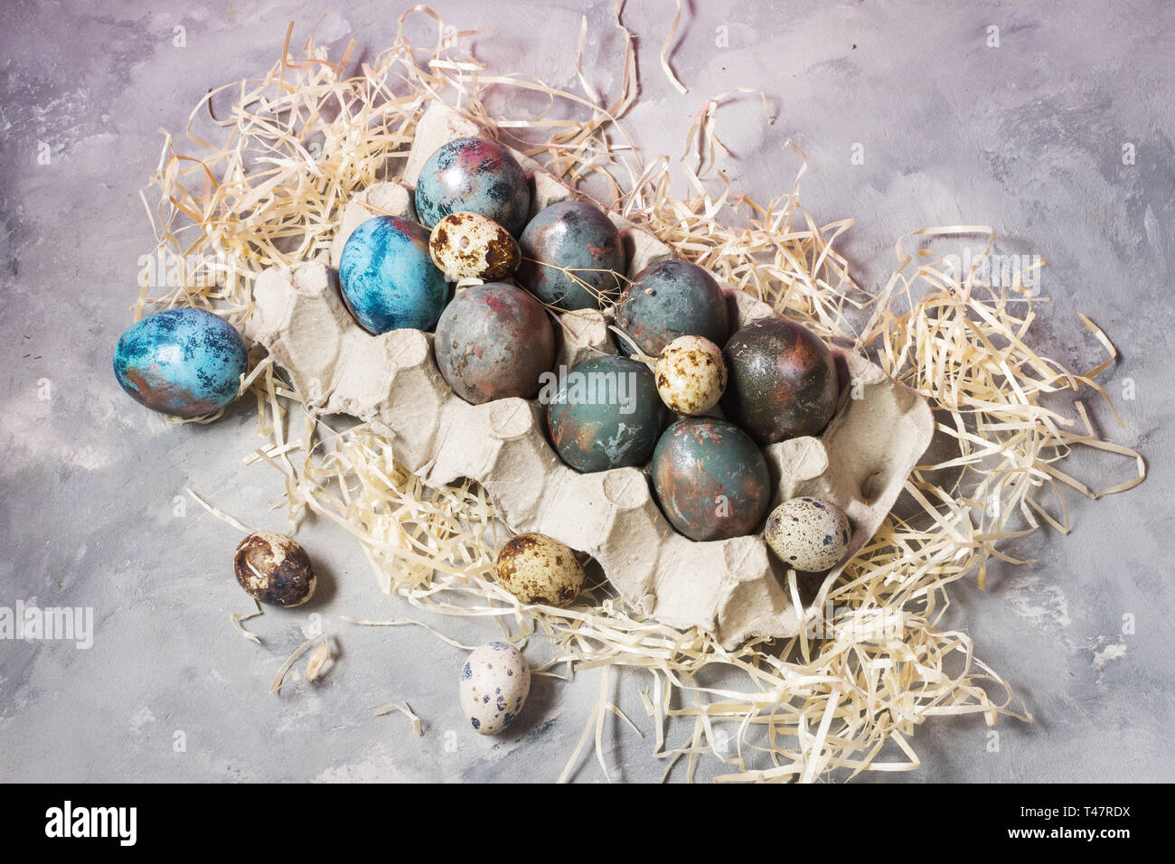 Quail and chicken painted eggs on concrete background. Easter decorations. Stock Photo