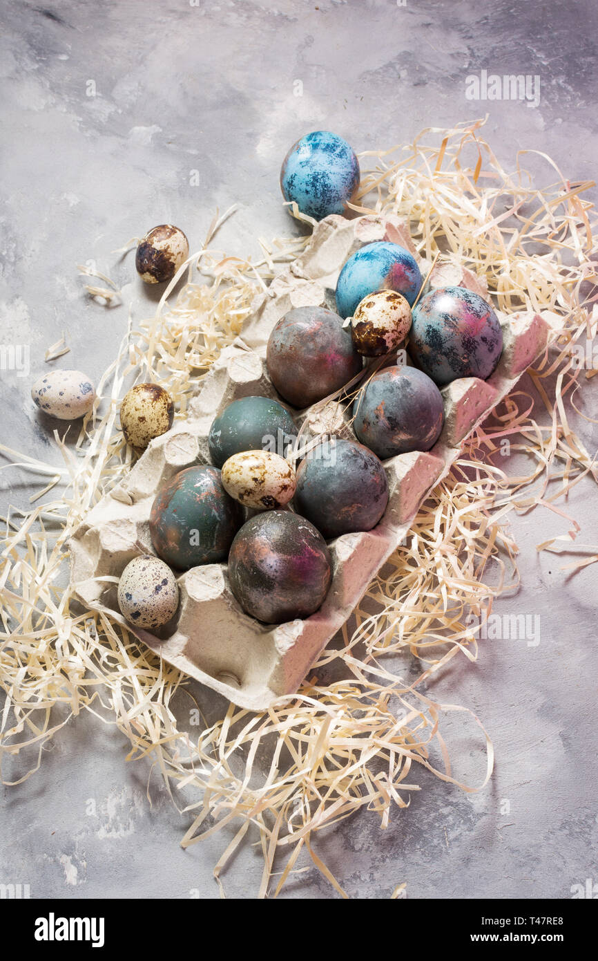 Quail and chicken painted eggs on concrete background. Easter decorations. Stock Photo