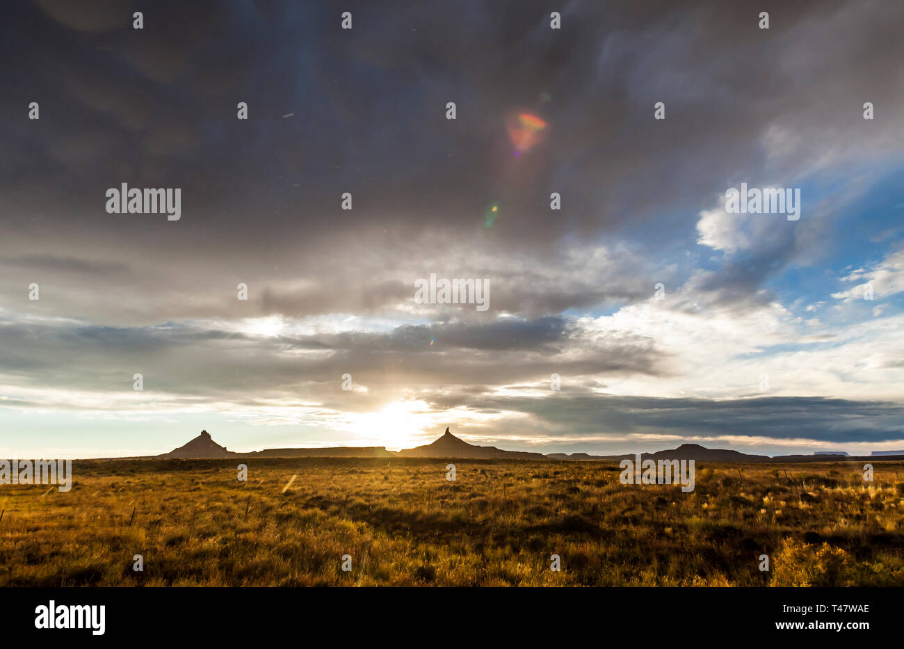 Rain falling from the sky after a storm passes and the sun sets over Canyonlands National Park in Southeast Utah, USA. North and South Six-Shooter Pea Stock Photo
