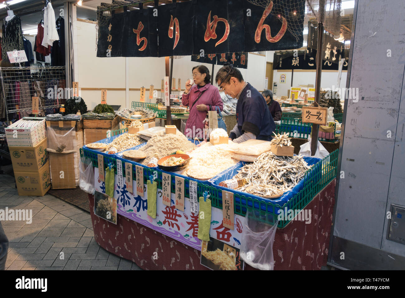 Japanese vendor in his stall, selling seafood and local food in the city of Tokyo, Japan Stock Photo