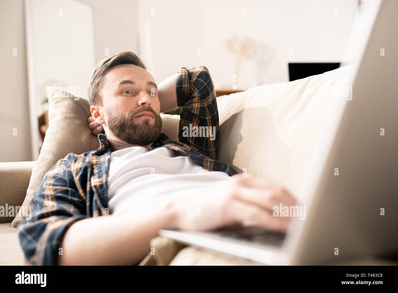 Watching video on couch Stock Photo