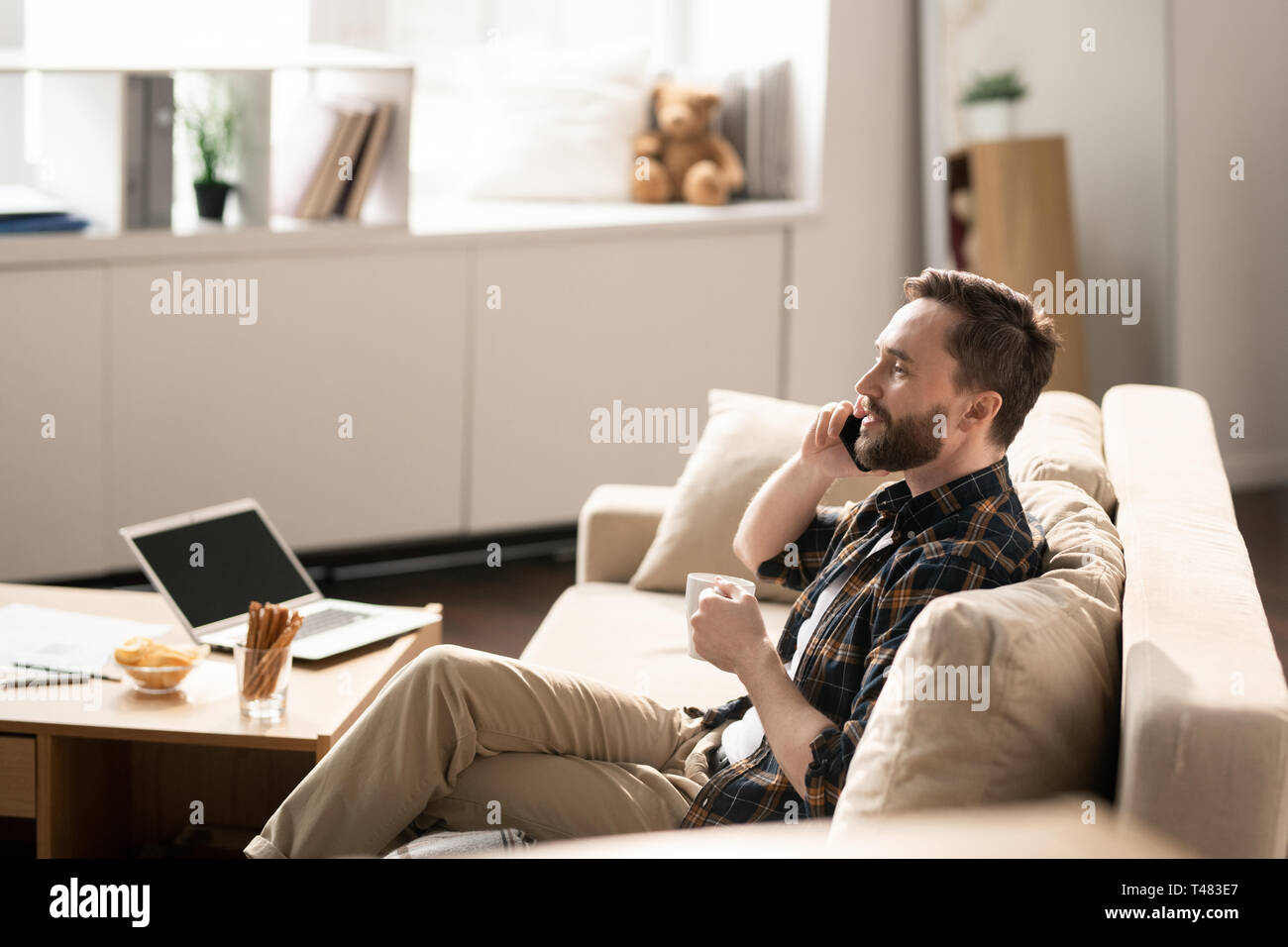Talking by phone on couch Stock Photo