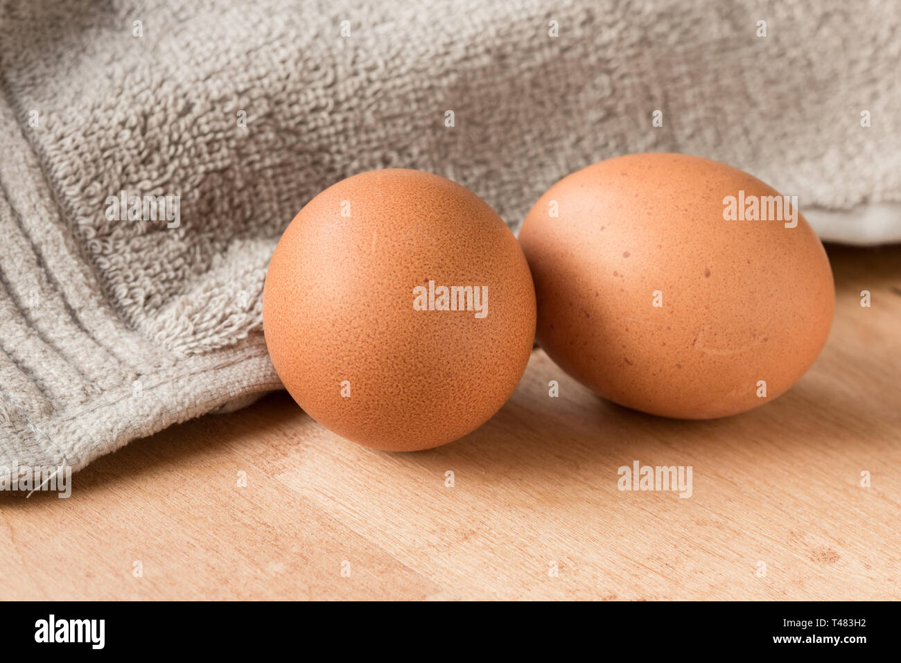Two brown eggs on a wooden kitchen table. Stock Photo