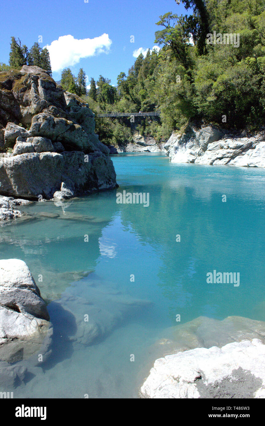 The magnificent ice blue of the Hokitika Gorge in midst of the rich green of the forest surrounding it, possible to be reached by swing bridge Stock Photo