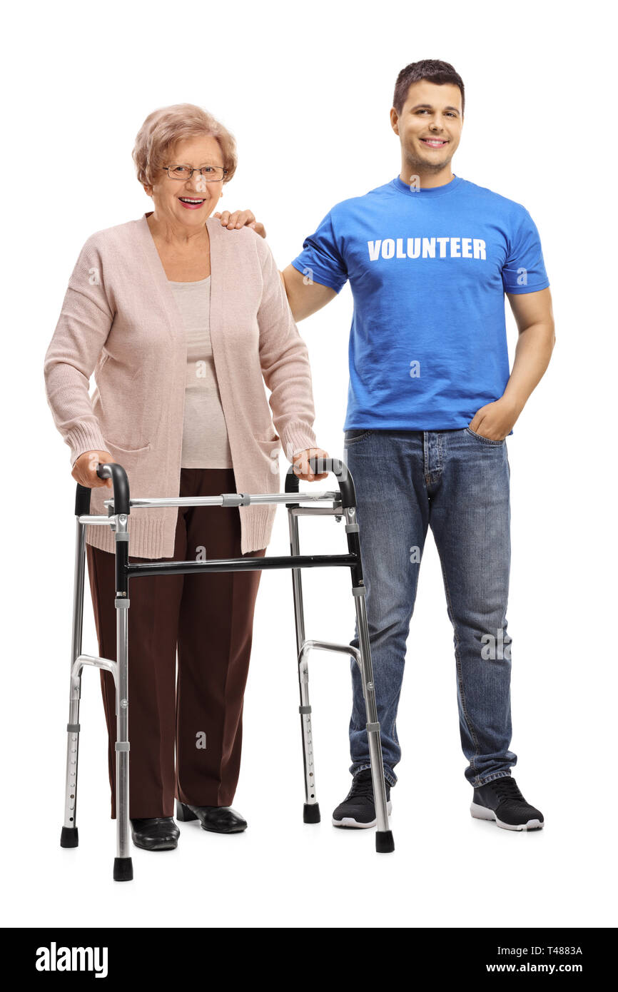 Full length portrait of a young man volunteer and a senior woman with a walker isolated on white background Stock Photo