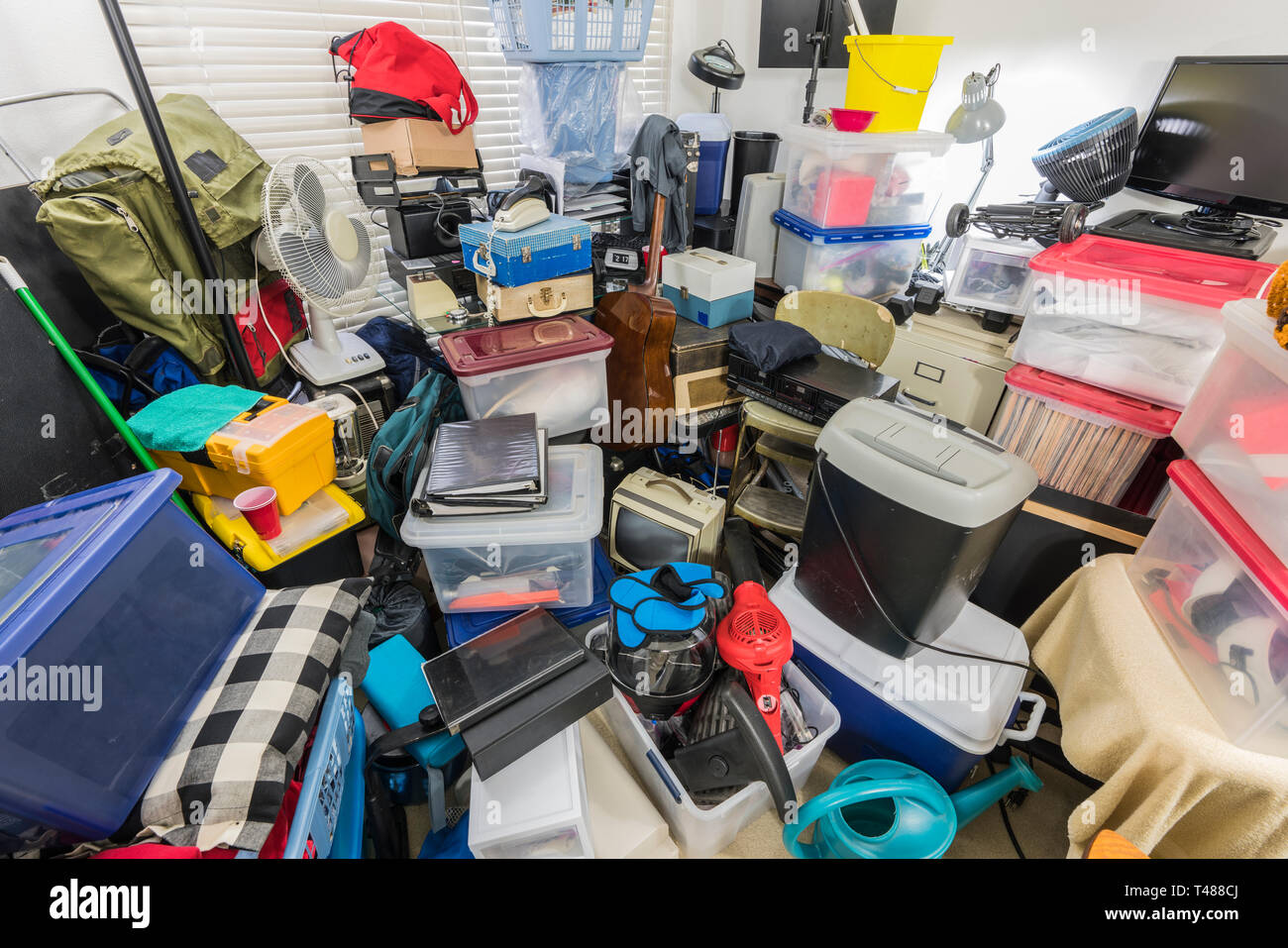 Packed storage room filled with boxes, files, electronics, business equipment, sporting goods and household items. Stock Photo