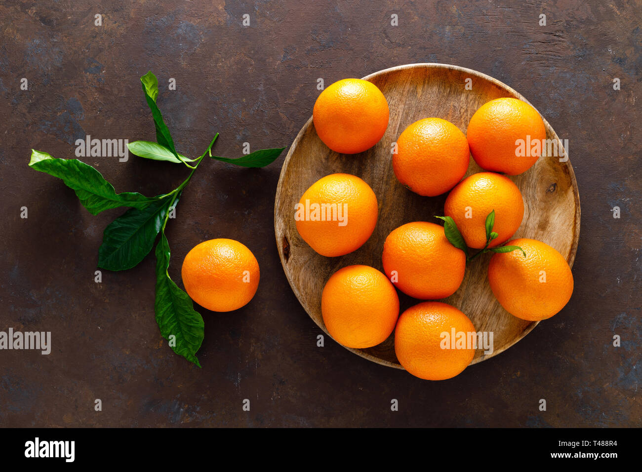Oranges with leaves on dark background, top view Stock Photo