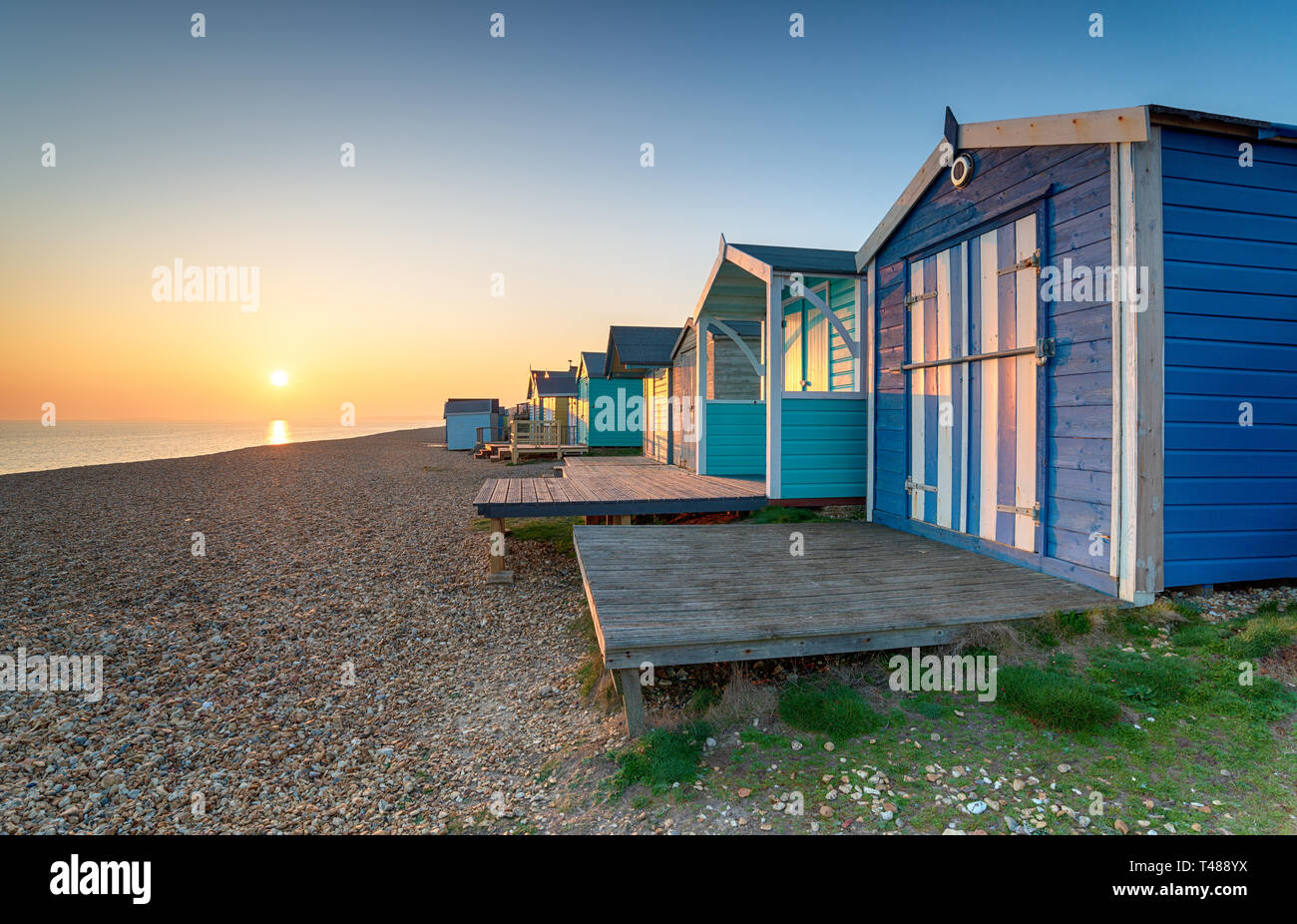 Beautiful sunset over beach huts at Milford on Sea on the Hampshire coast Stock Photo