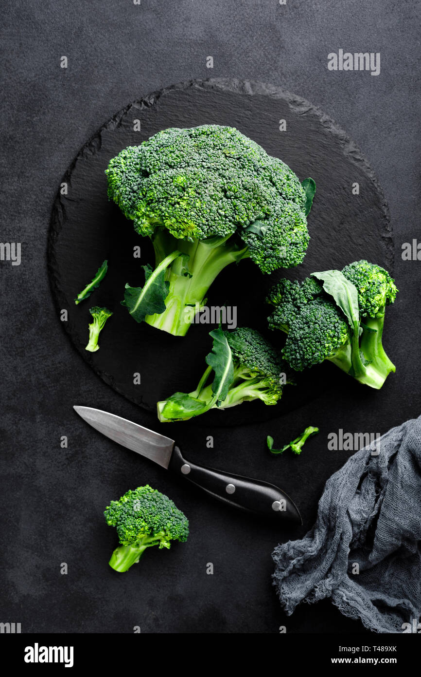 Fresh broccoli florets on black background, top view Stock Photo