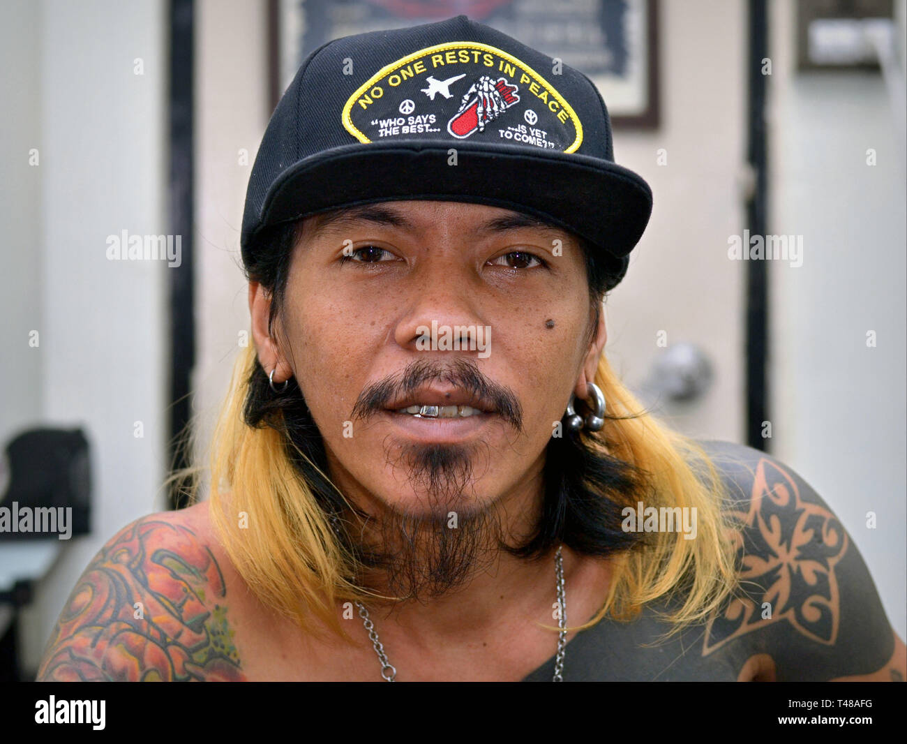 Young Thai tattoo artist poses for the camera. Stock Photo