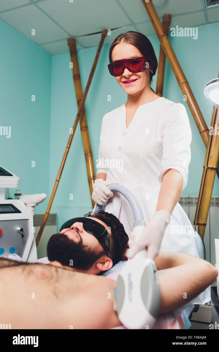 Men Lying At Beautician S During Laser Armpit Hair Removal Therapy