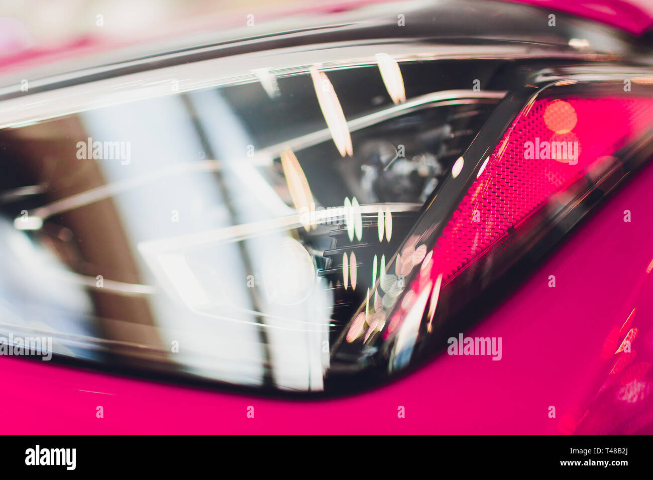 Close up shot headlight in luxury pink car background. Modern and expensive sport car concept. Stock Photo