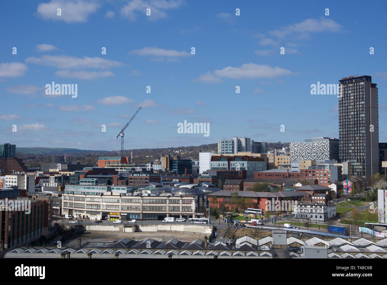 View of Sheffield City Centre across valley from Park Hill on a bright day with a few clouds in the blue sky Stock Photo