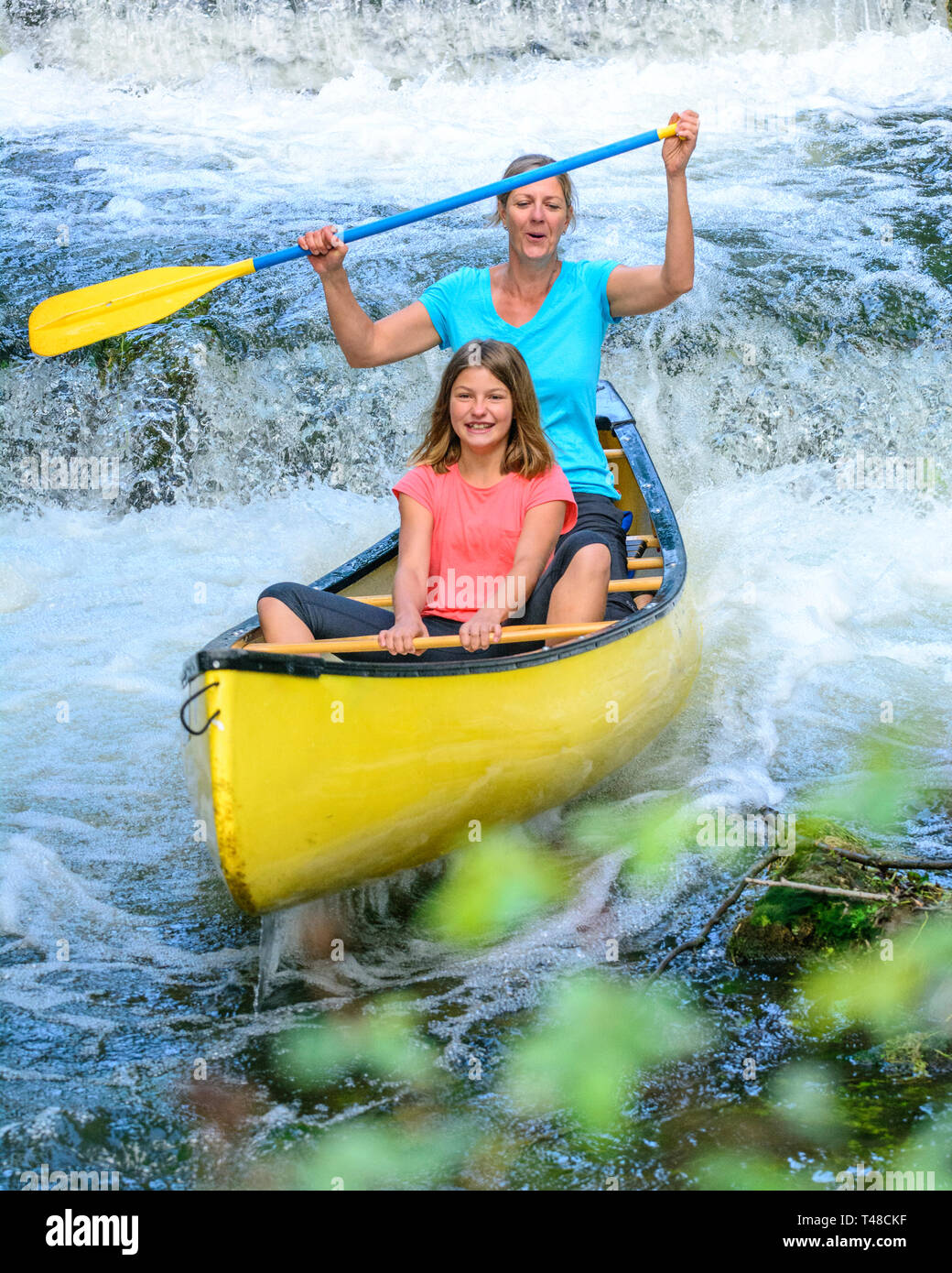 Women paddling down a weir in a canoe Stock Photo Alamy