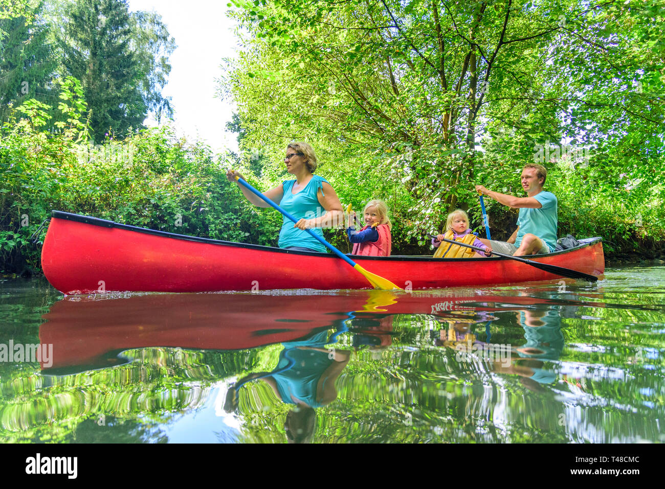 Family in canoe on tour on an idyllic river Stock Photo
