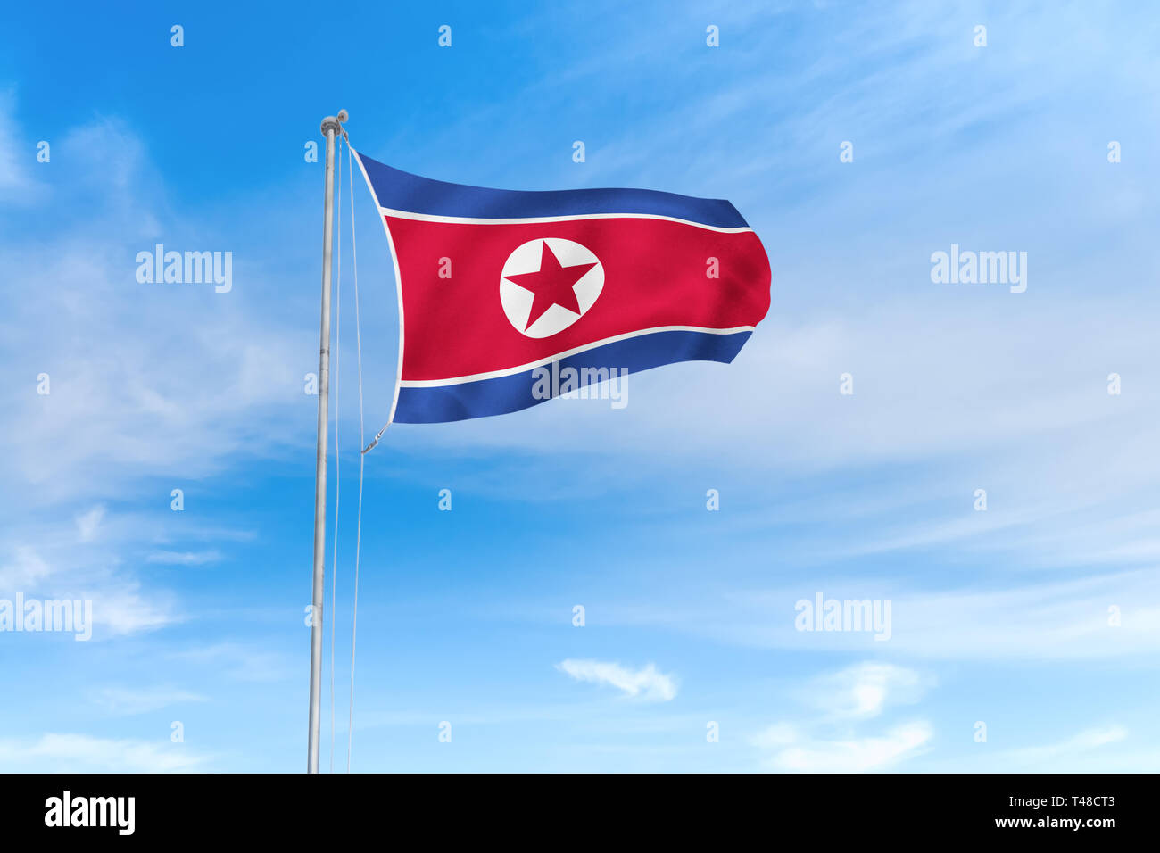 North Korea flag blowing in the wind over nice blue sky background Stock Photo