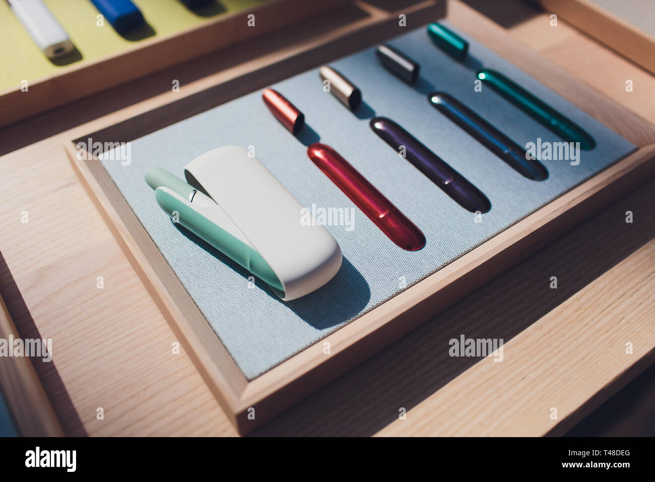 New design. Showcase with a large multi-colored selection System of heating of tobacco. Color devices for smoking. New technology of electronic Stock Photo