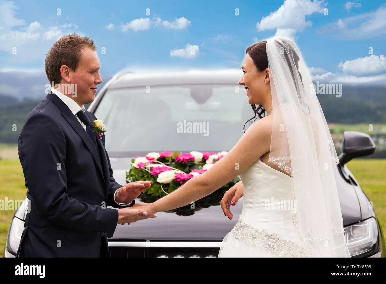 Bride and groom in front of the wedding car Stock Photo - Alamy