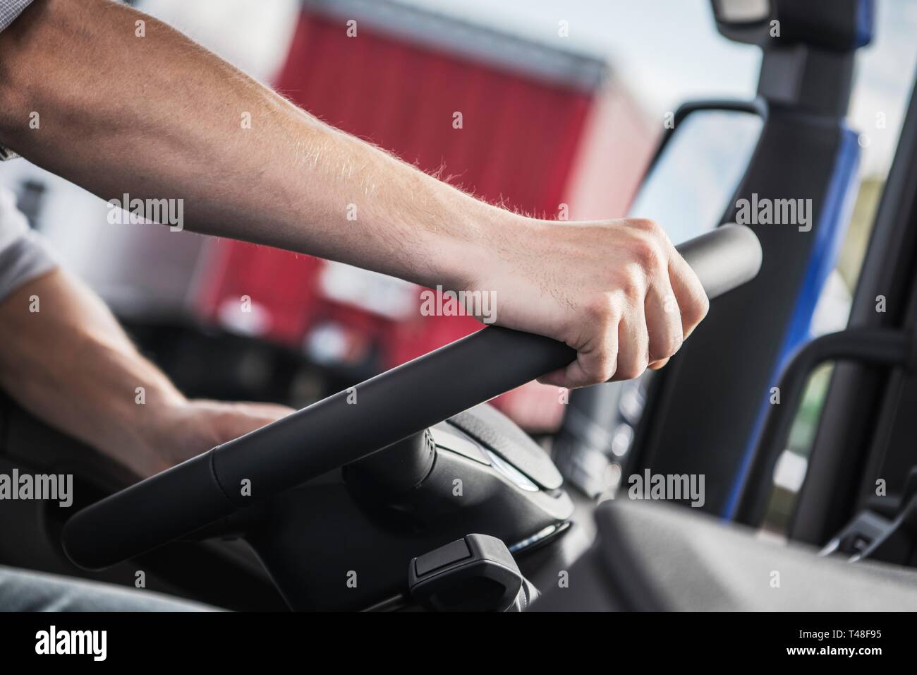 Hand on Truck Steering Wheel. Caucasian Trucker on the Road. Closeup